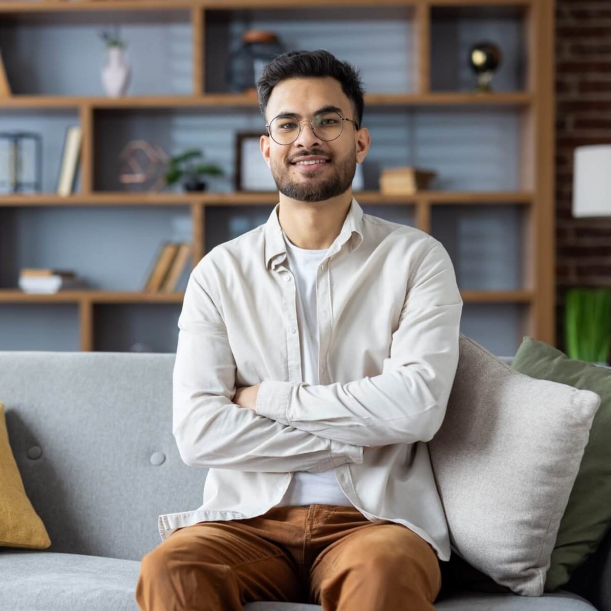 | smiling young indian man sitting on sofa at home 2026 03 24 22 21 21 utc e1775535560714
